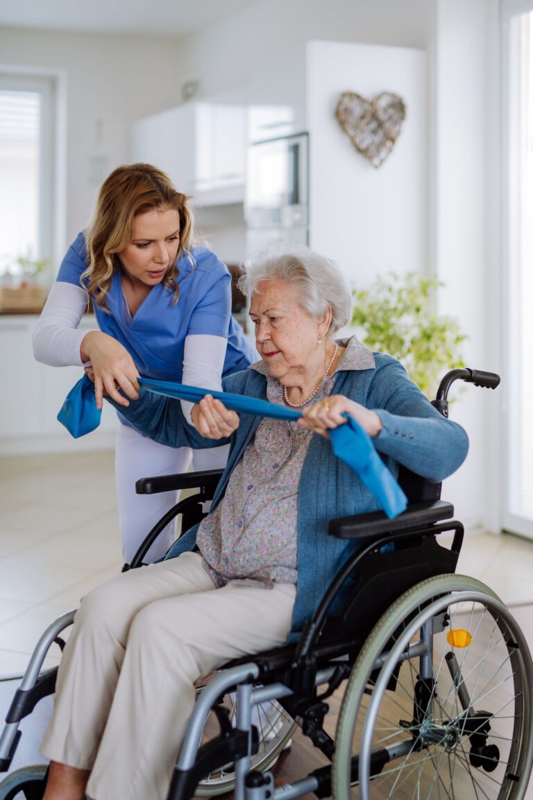 nurse exercising with senior woman at her home, concept of healthcare and rehabilitation.